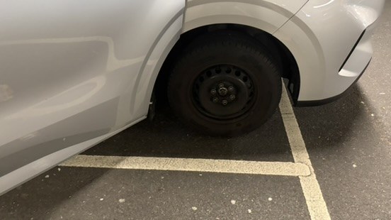 Front wheel of the van with no hubcap fitted, photographed in the car hire facility