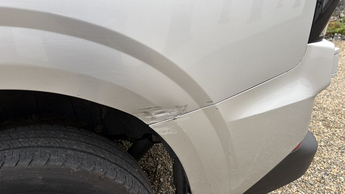 Close view of the scrape where the rear quarter panel meets the bumper