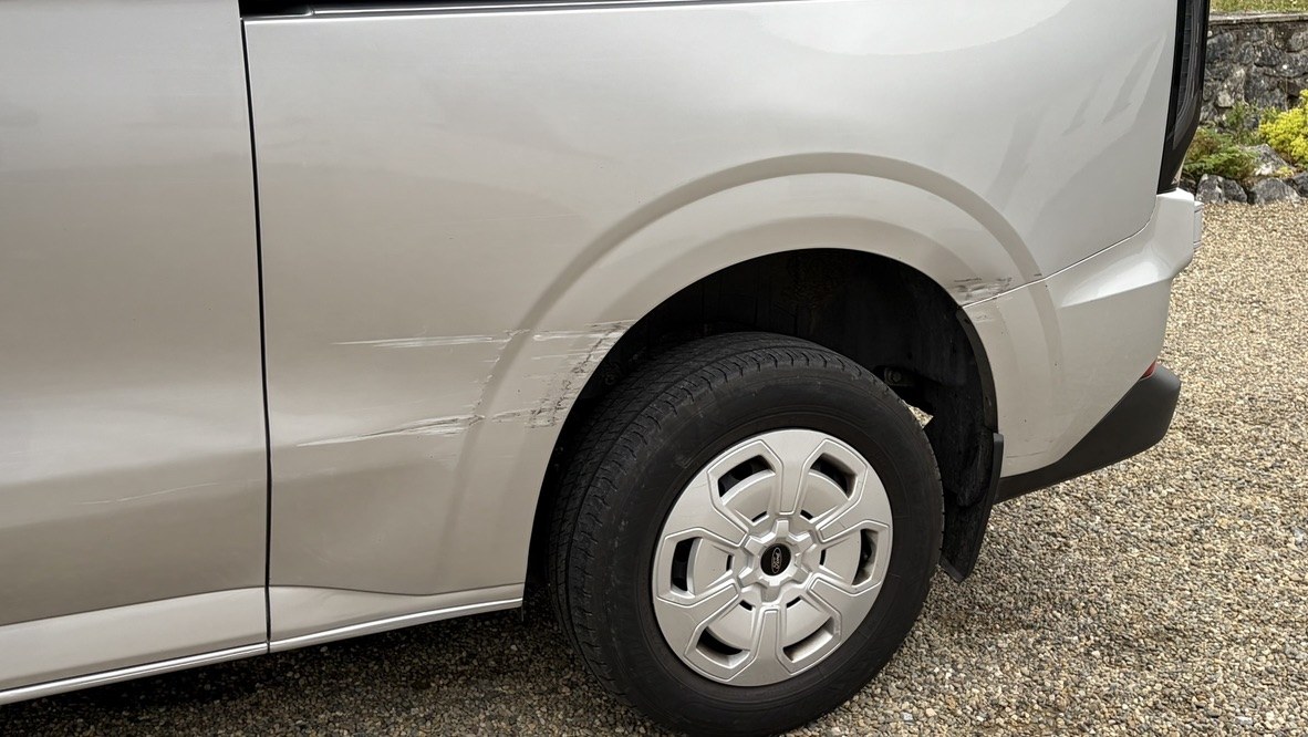 The rear passenger quarter panel showing the scrape along the body line